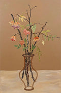 Autumn branches and small flowers in a slim glass vase on tan