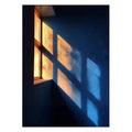 Golden window light falling on a deep blue wall