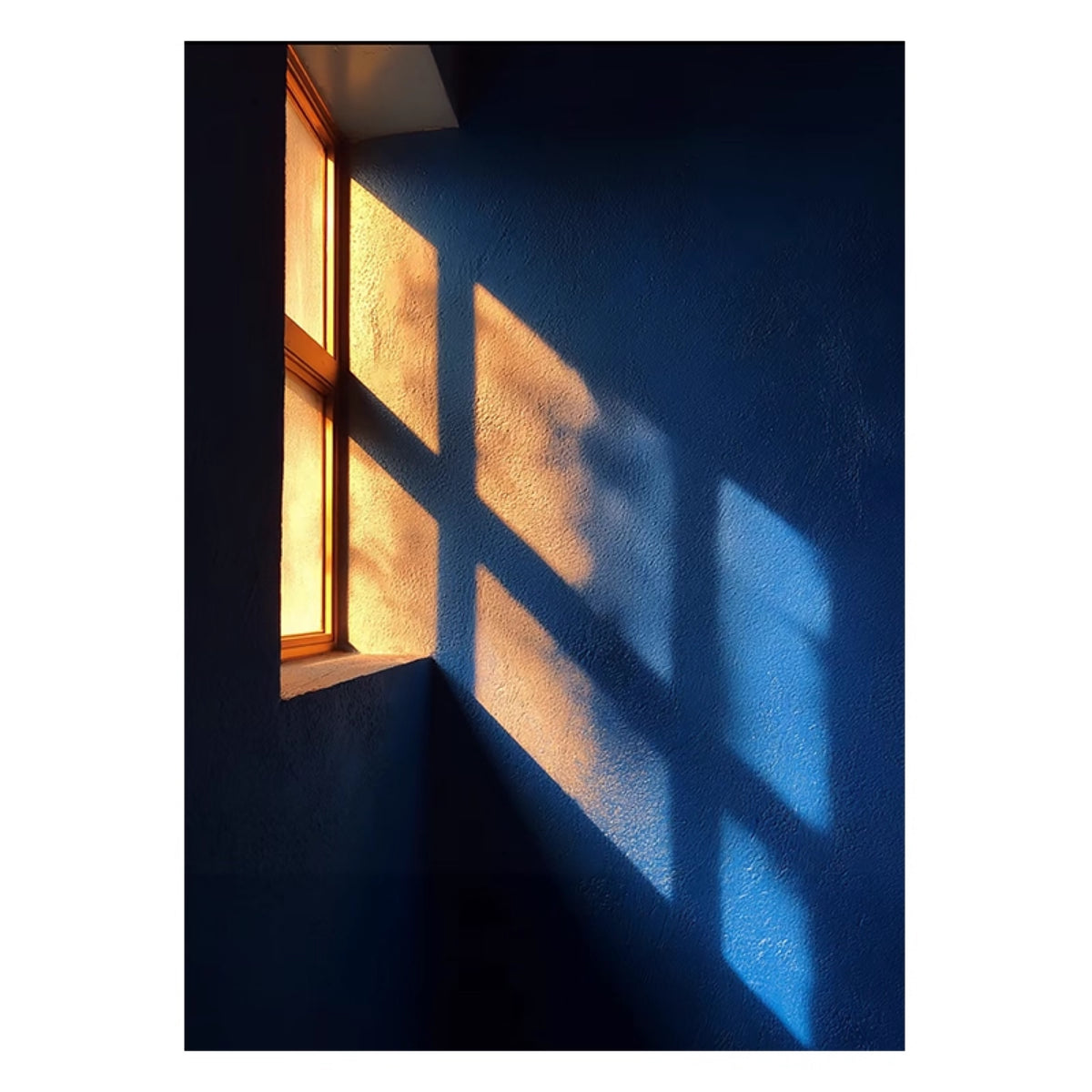 Golden window light falling on a deep blue wall