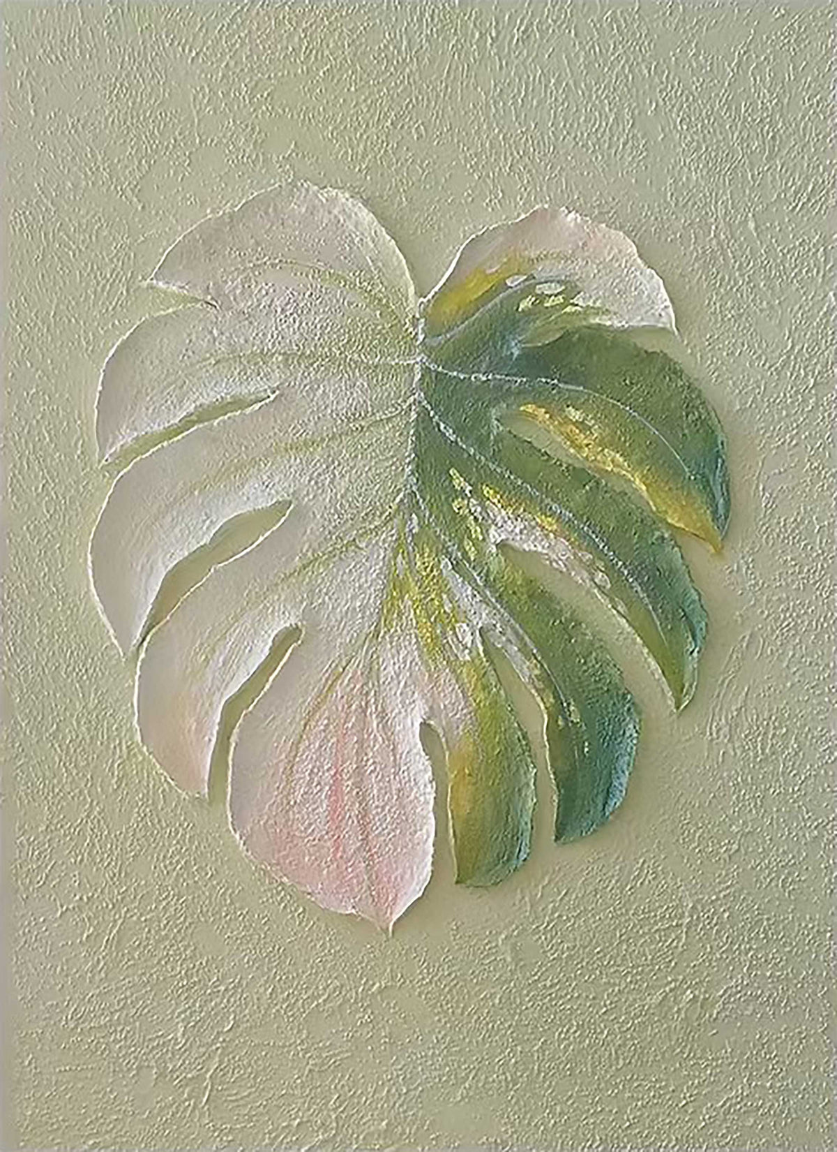A pale monstera leaf sculpted on a textured linen ground