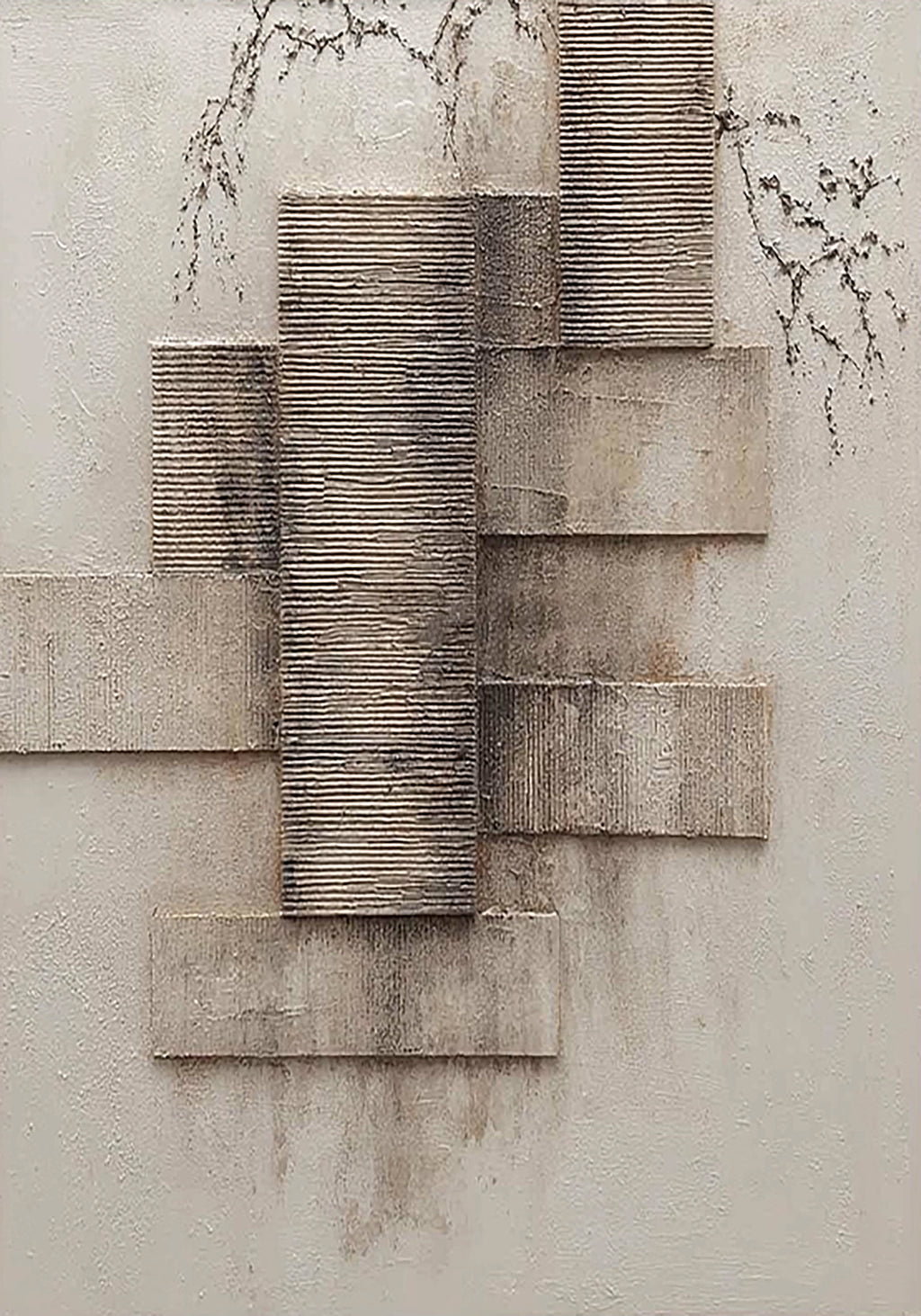 Textured grey blocks stacked beside fine bare branches