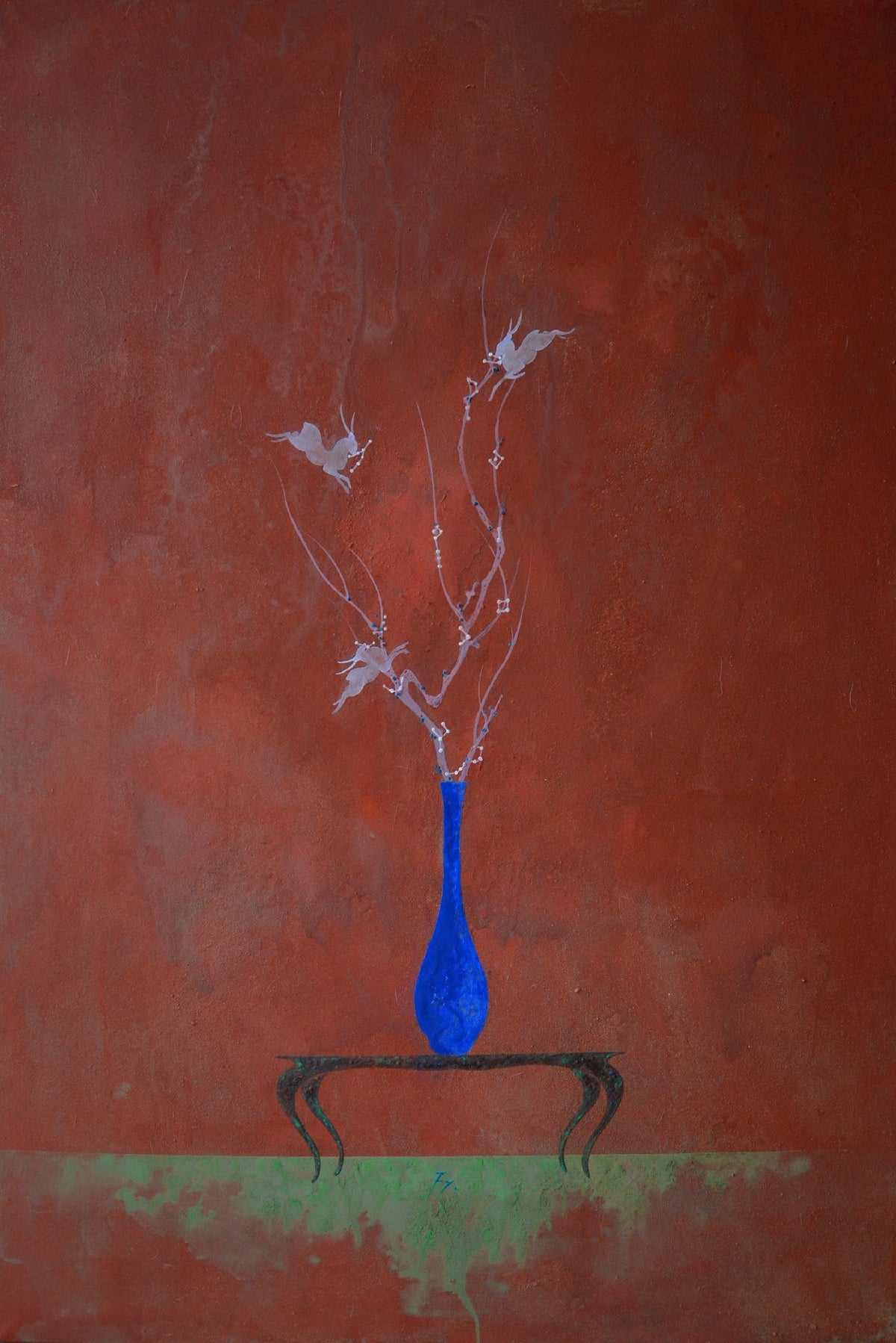 A slender blue vase with pale sprigs on a small table on oxblood