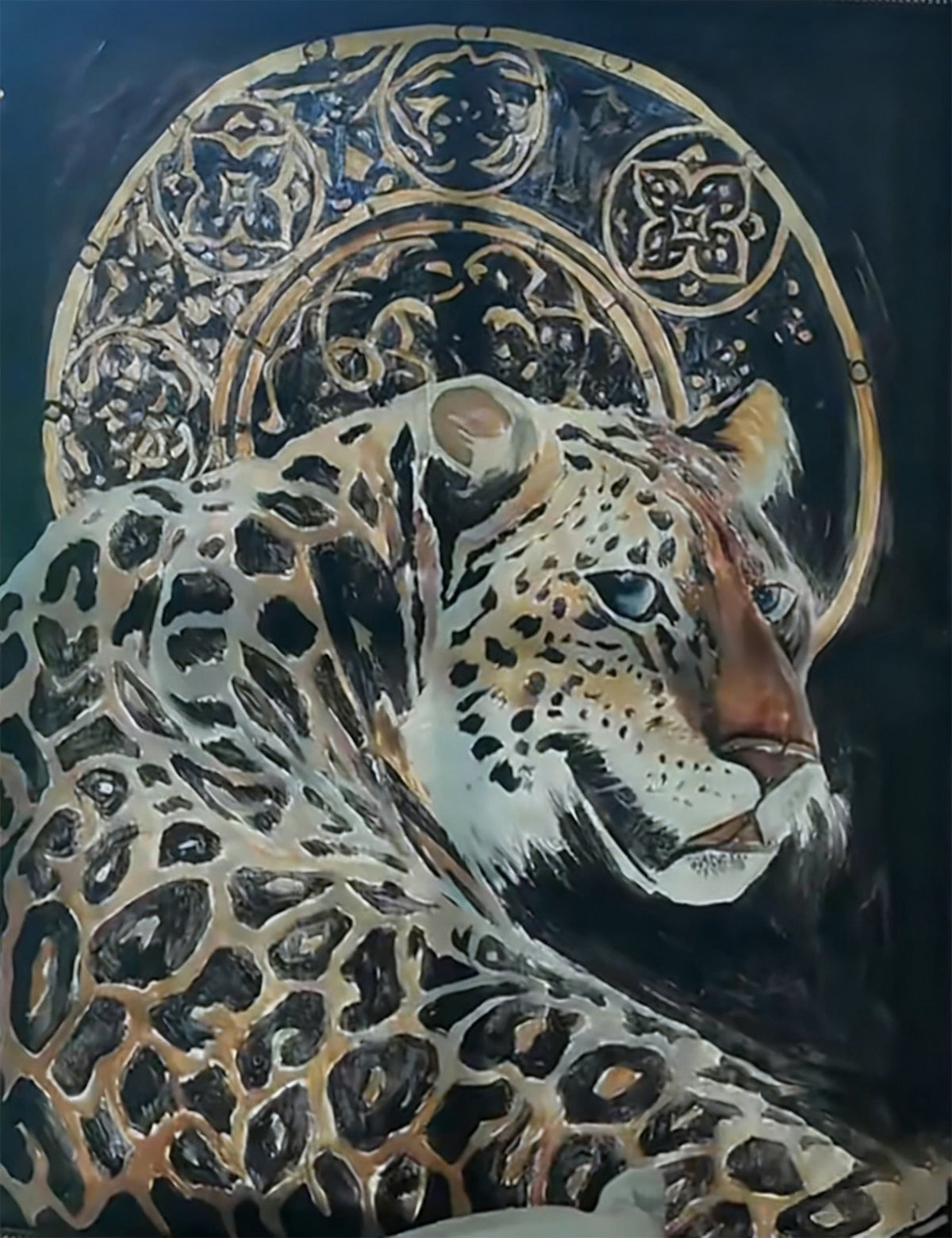 A leopard lying before a gold ornamental halo on black