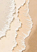 Two lines of white foam washing over pale peach sand