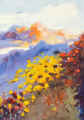 Yellow and red blooms on a hillside under violet mountains