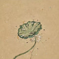 A single green lotus leaf on a speckled kraft-brown ground