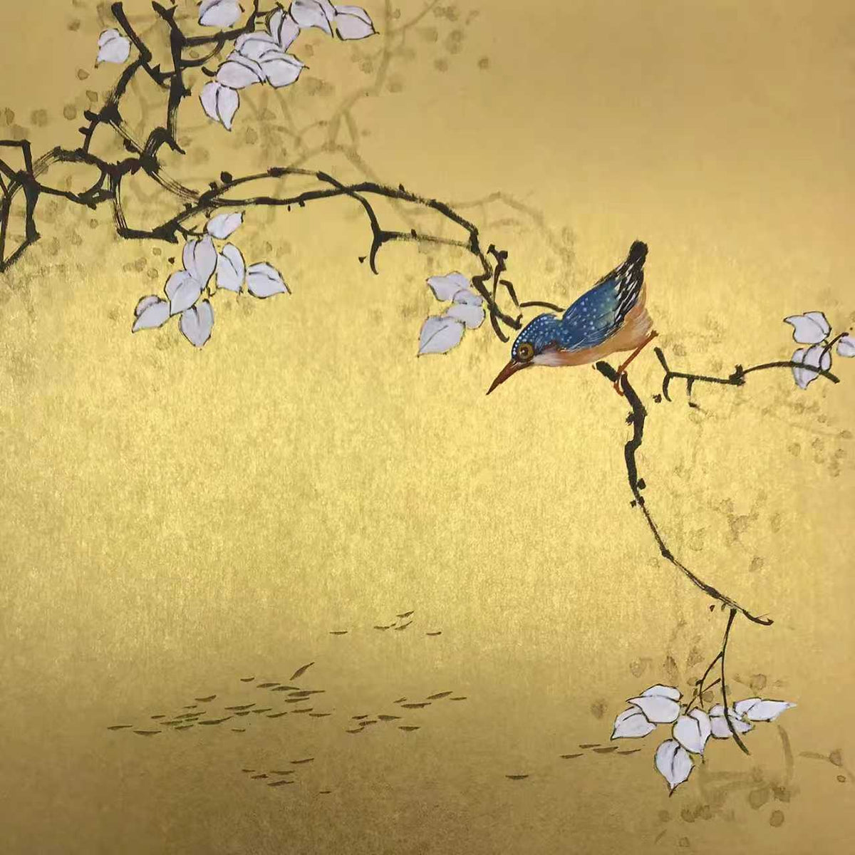 A kingfisher on a dark branch with white blossoms on gold