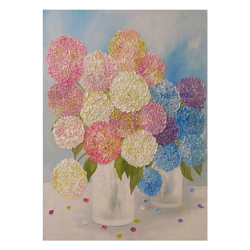 Pink, blue and lilac hydrangeas in two clear vases