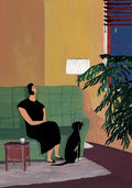 A woman in black resting on a green sofa beside her black dog