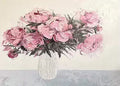 Pink peonies in a clear vase on pale grey