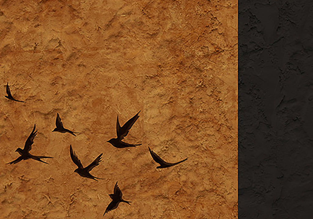 Black swallows wheeling over a rough ochre field beside a black band