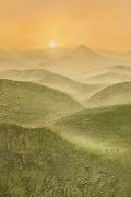 A soft sunrise above layered misty green hills