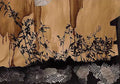 Black ink plants above a band of silver honeycomb on tan