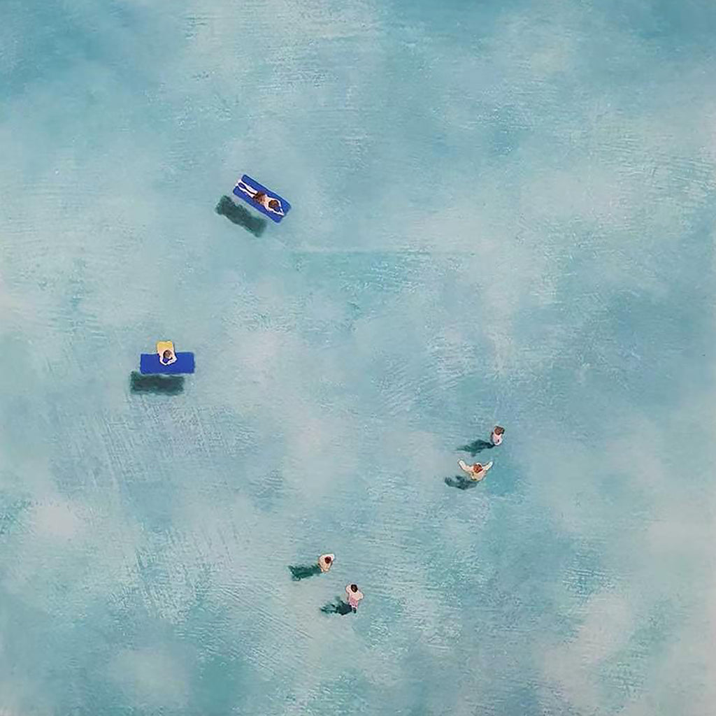 Tiny swimmers and floats drifting in a hazy blue sea from above