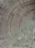 Fine concentric grooves carved in grey textured paint