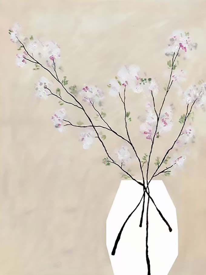 Pale blossom branches in a white faceted vase