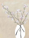 Pale blossom branches in a white faceted vase