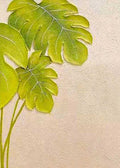 Two lime-green monstera leaves on a textured cream wall