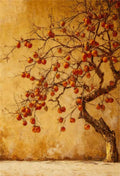 A persimmon tree full of red fruit beside a golden wall