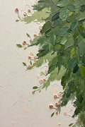 Green foliage tumbling down a cream wall with small pink buds