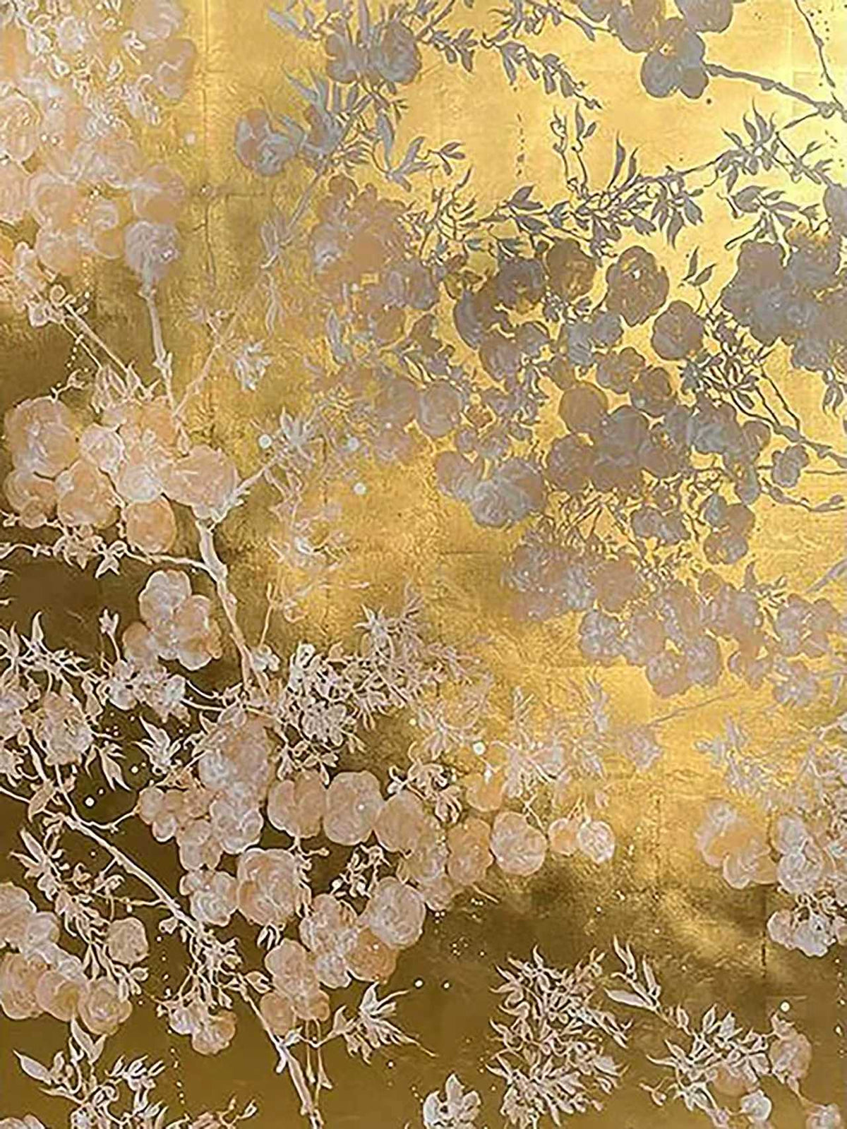 Pale blossoms and branches in silhouette over shimmering gold
