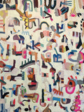 Dense scattered glyph-like shapes in pink, blue and charcoal on cream