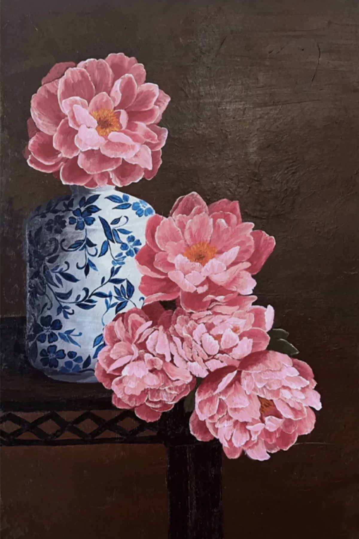 Pink peonies beside a blue-and-white porcelain jar on dark wood