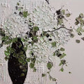Clusters of white blooms spilling from a black vase in thick relief