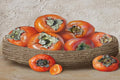 Ripe orange persimmons heaped in a woven basket