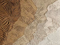 Sweeping bands of finely carved leaf patterns in tan, cream and umber