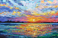 A blazing sunset over a lake painted in vivid bands of purple, orange, teal and gold