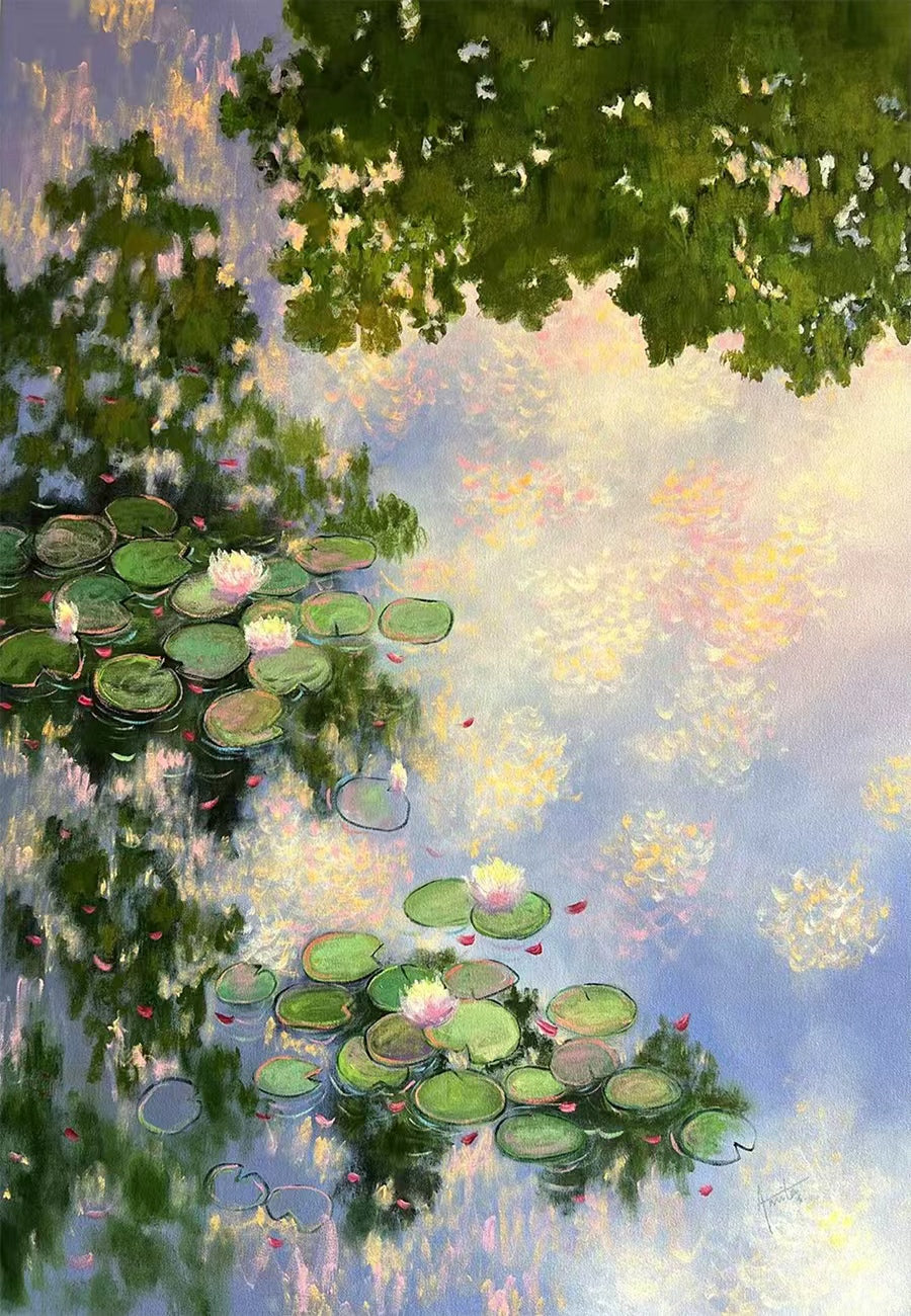 Lily pads and pink blossoms floating on water that mirrors leafy branches and a lilac sky