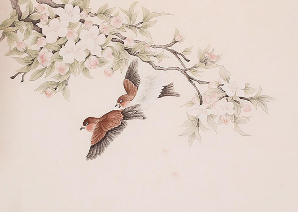 Two sparrows fluttering beneath a spray of apple blossom