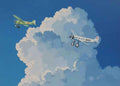 Two vintage planes flying past towering white clouds in deep blue