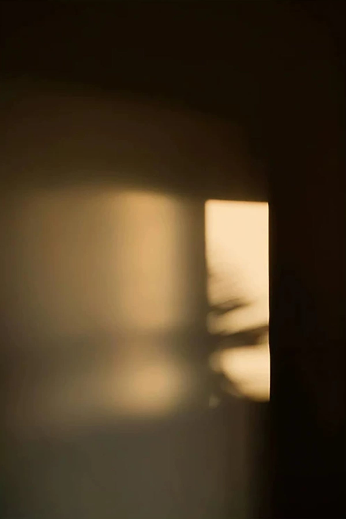 A narrow bar of golden evening light glowing in a dark doorway