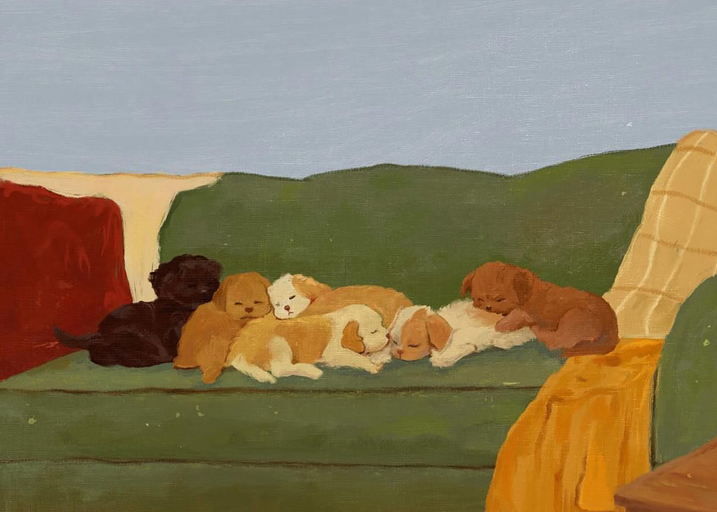 A sofa crowded with sleeping puppies in brown, tan and cream, a mustard throw at the end