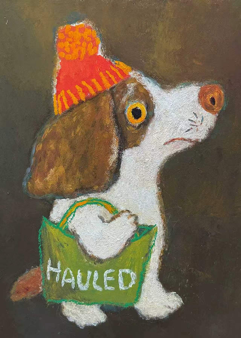 A worried-looking spaniel in an orange pom-pom hat carrying a green tote bag