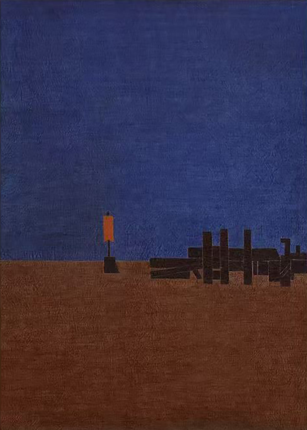 A deep blue sky over a brown shoreline, with an old pier and a single orange marker light