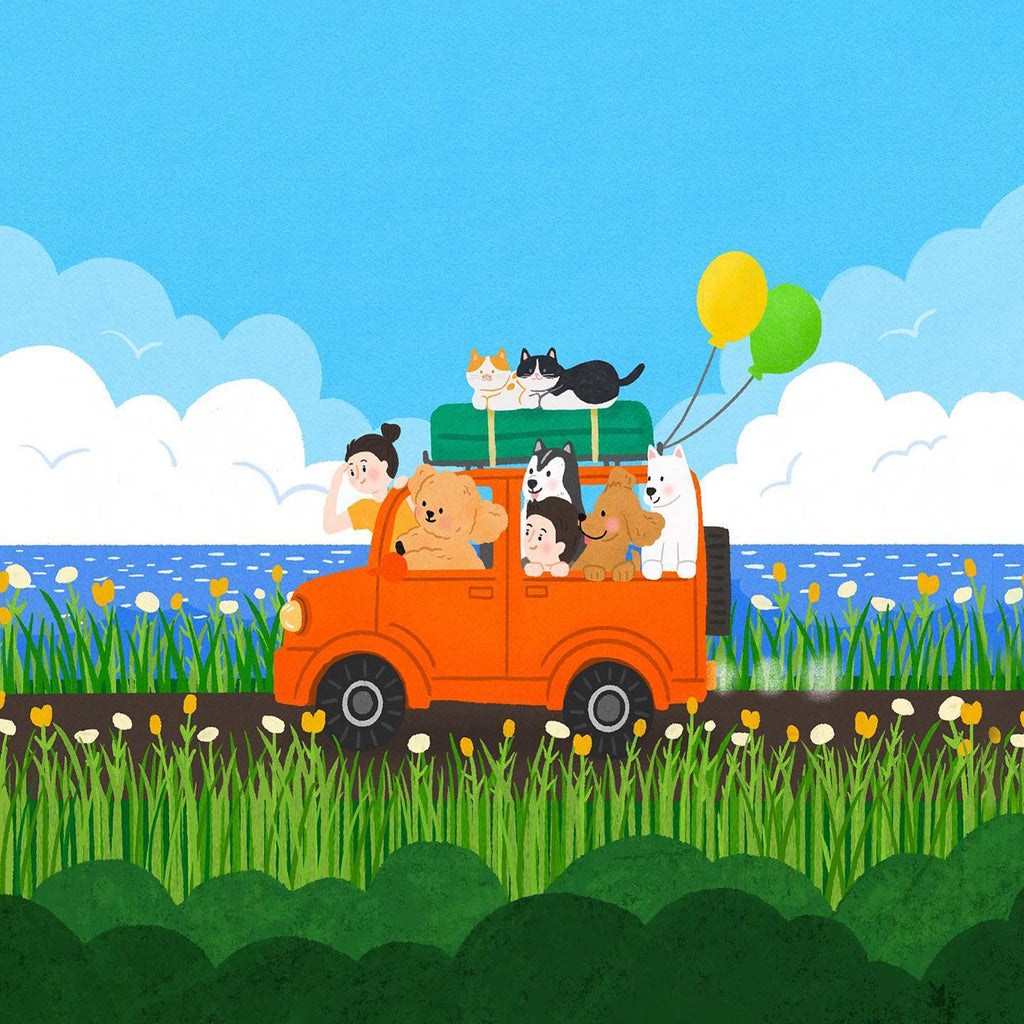 A family in an orange van loaded with dogs and a cat, balloons trailing, driving past the sea
