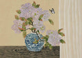 Lilac hydrangeas in a blue-and-white jar on a wooden table, a small butterfly beside a linen curtain