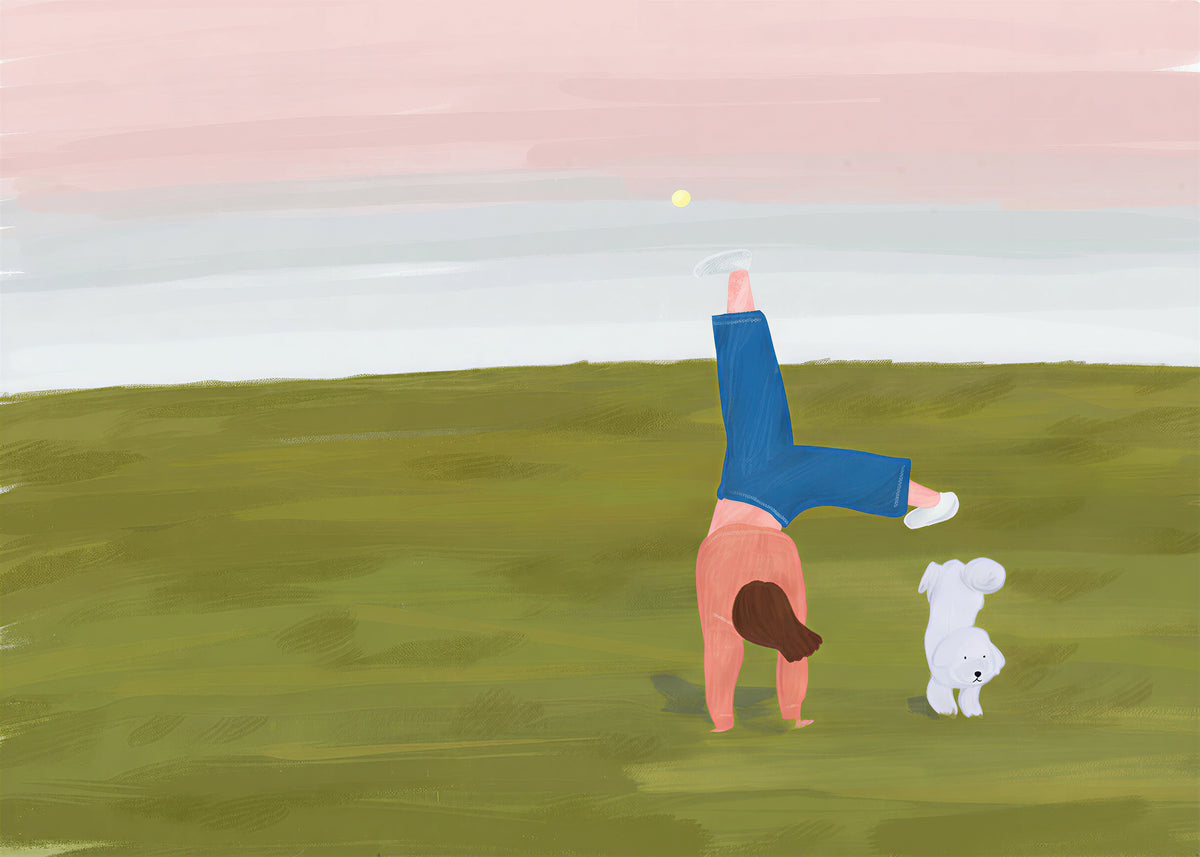 A girl doing a cartwheel on a green hill at dusk while her little white dog watches