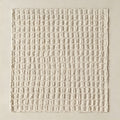 A hand-sculpted lattice of raised ivory squares on a cream ground