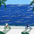 Two riders on mint and blue scooters along a seaside promenade beside a sparkling deep-blue sea