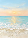 Foamy surf rolling onto pale sand under a soft peach and blue sunset
