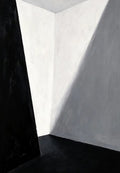 A bare corner of white walls cut by a sharp diagonal shadow