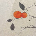 Two bright persimmons on a bare branch casting soft leaf shadows on a textured white wall