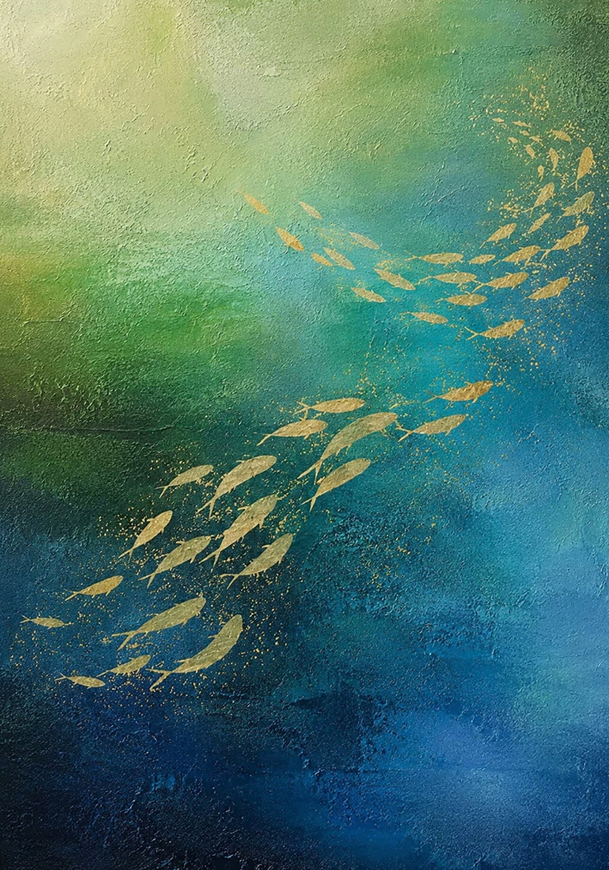 A school of golden fish curving through teal and deep-blue water