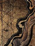 A city map in gold and black, cut through by a sculpted winding river