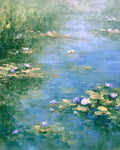 Violet and pink water lilies floating on a soft blue pond edged with reeds