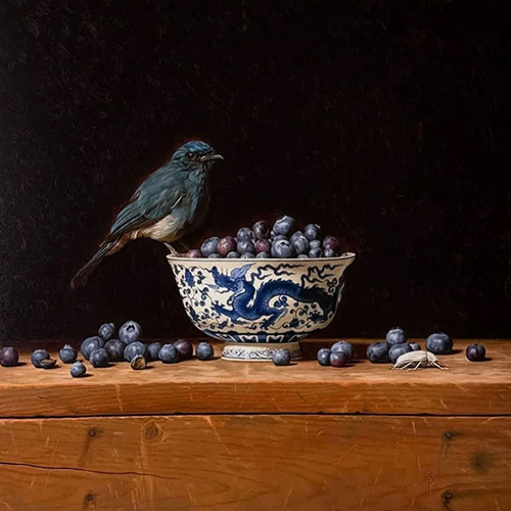 A small blue bird perched on a blue-and-white bowl of blueberries, on a dark wooden shelf